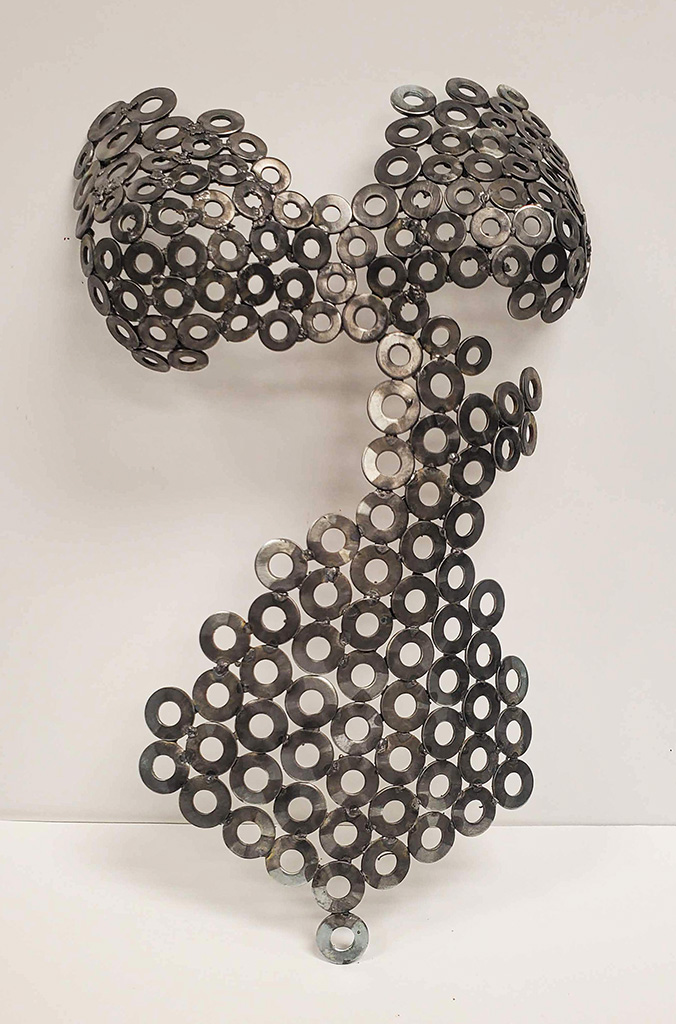 Using washers that I welded together I sculpture the front of a female body.